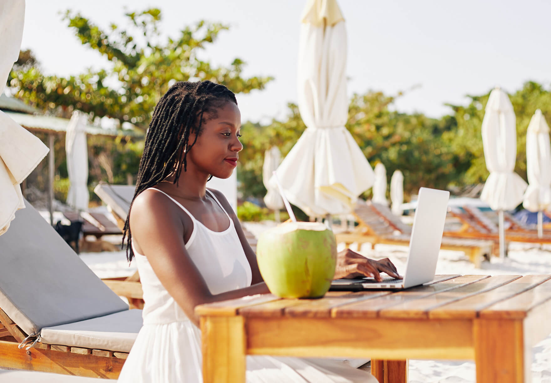 Woman working remotely from a beach destination